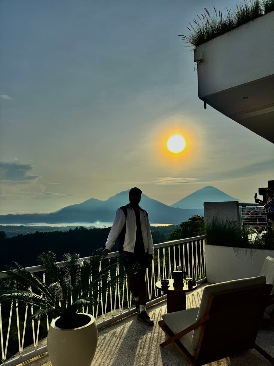 Silhouette overlooking mountains and a lake at sunrise