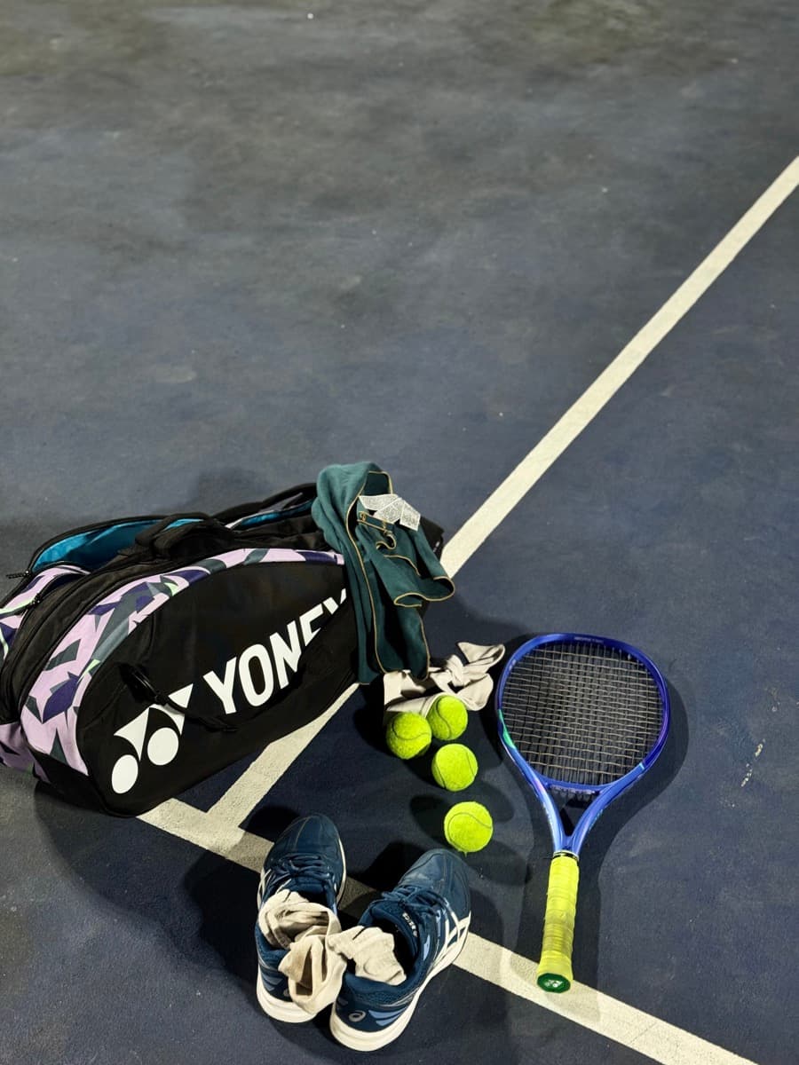 Tennis racket, balls, shoes and bag on a court