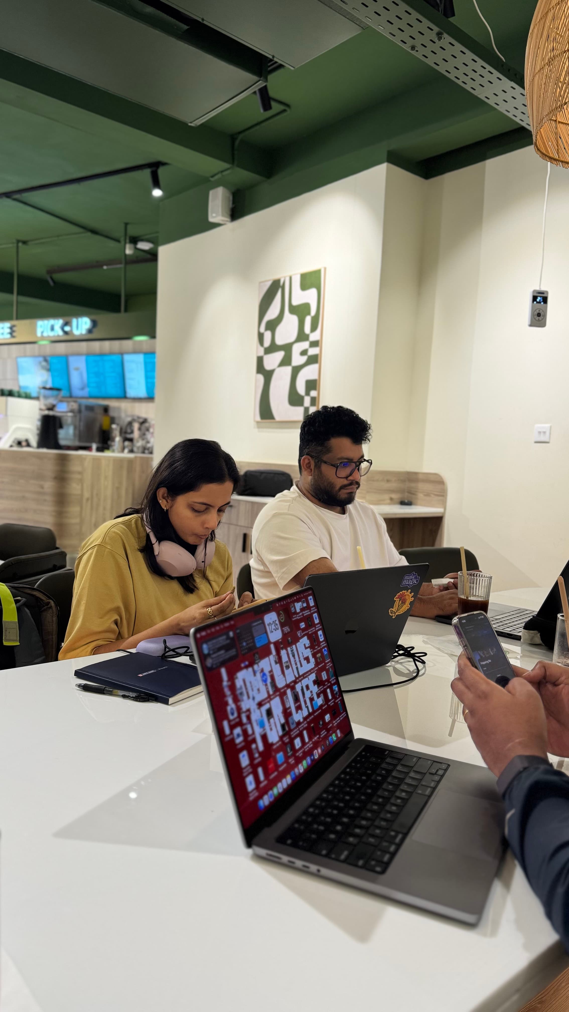 Friends working together on laptops in a café