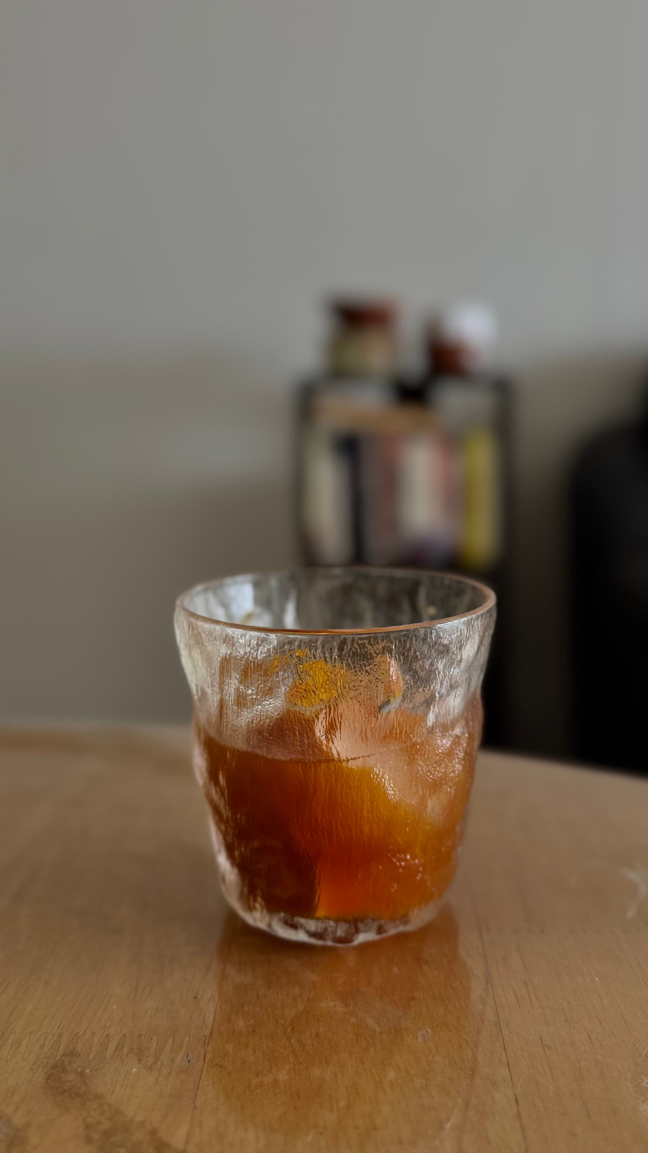 An amber iced drink in a textured glass