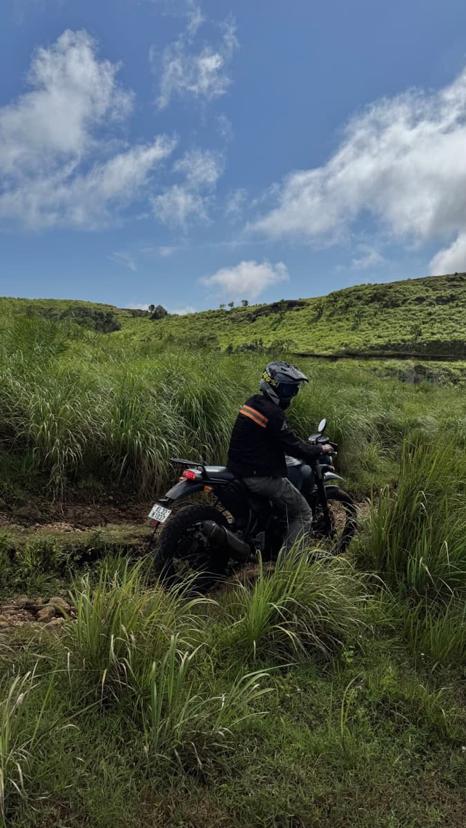 Motorcycle rider on a grassy hillside